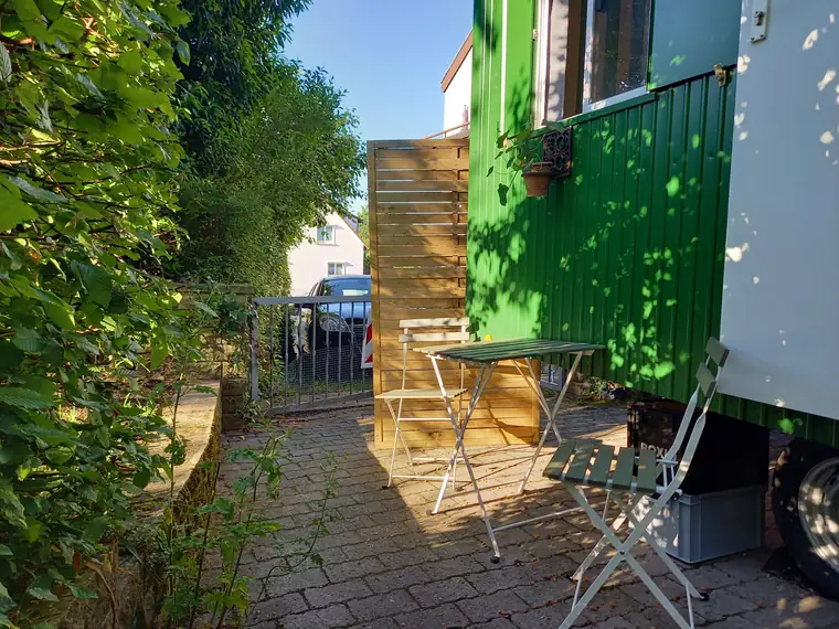 Sitzplatz vor dem grünen Bauwagen, Sichtschutz aus Palettenholz
