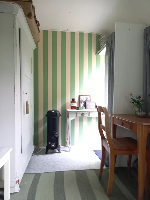 Innenraum mit Schrank, kleinem Ofen und Schreibtisch
