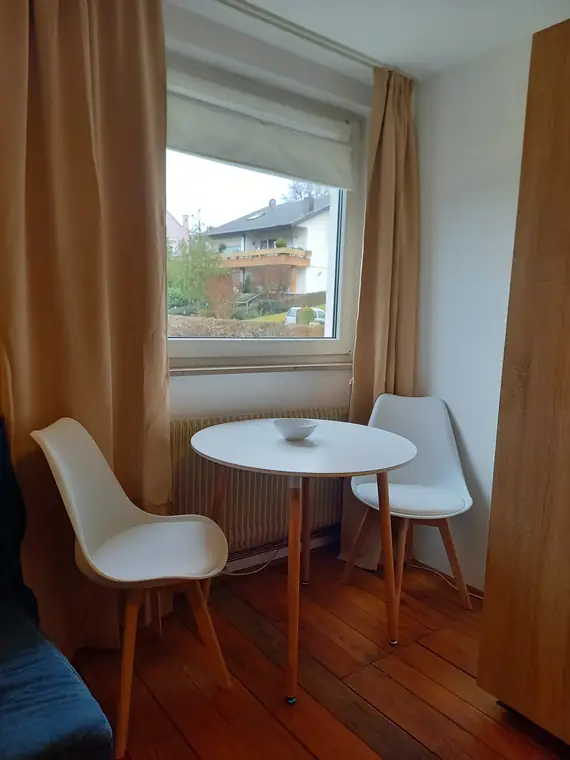 Runder Esstisch mit zwei Stühlen am Fenster