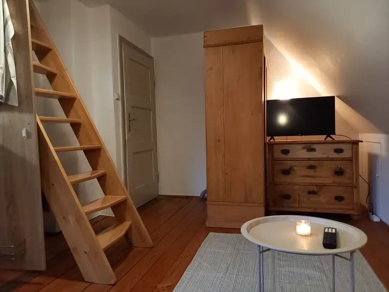 Bezogenes Bett auf der Schlafempore unter der Dachschräge